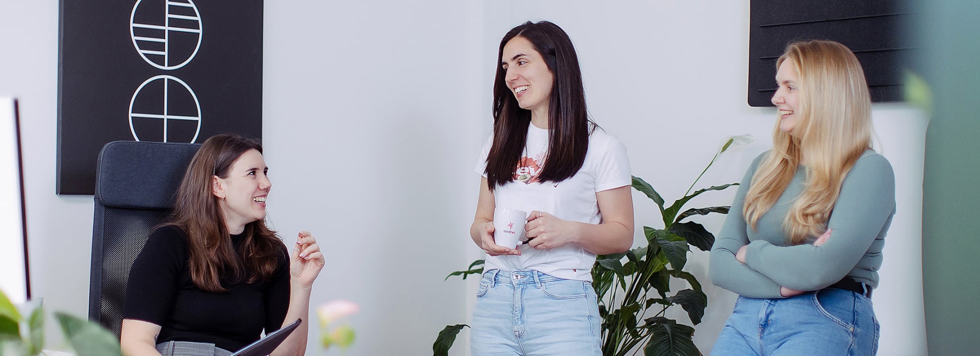 Drei Kolleginnen im Teamgespr&auml;ch in modernem B&uuml;ro