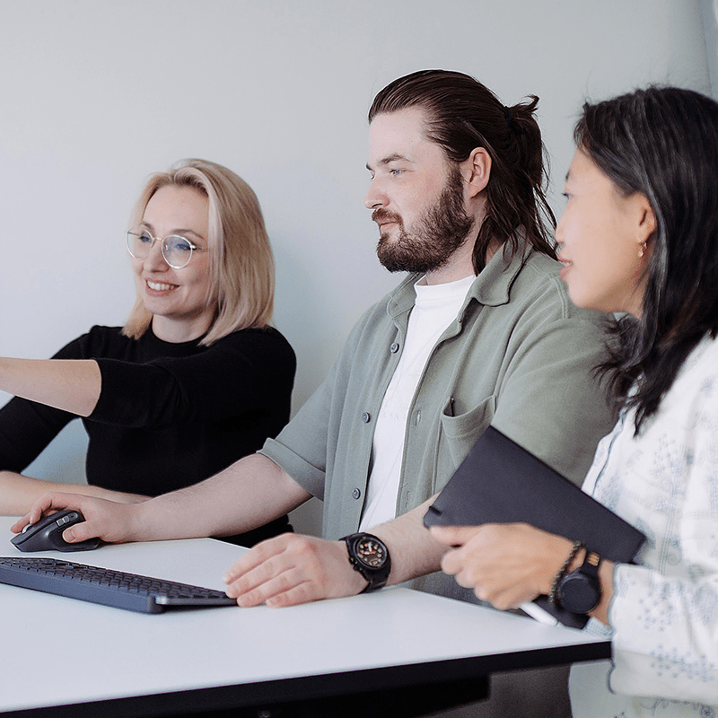 Drei Personen arbeiten gemeinsam an der Webentwicklung