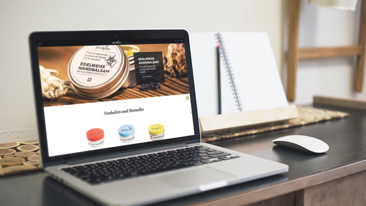 Laptop mit der ge&ouml;ffneten Puralpina-Website auf einem Arbeitsplatz.